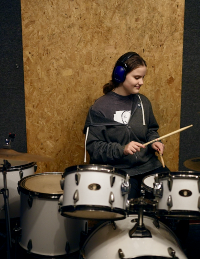 A young person playing drums.